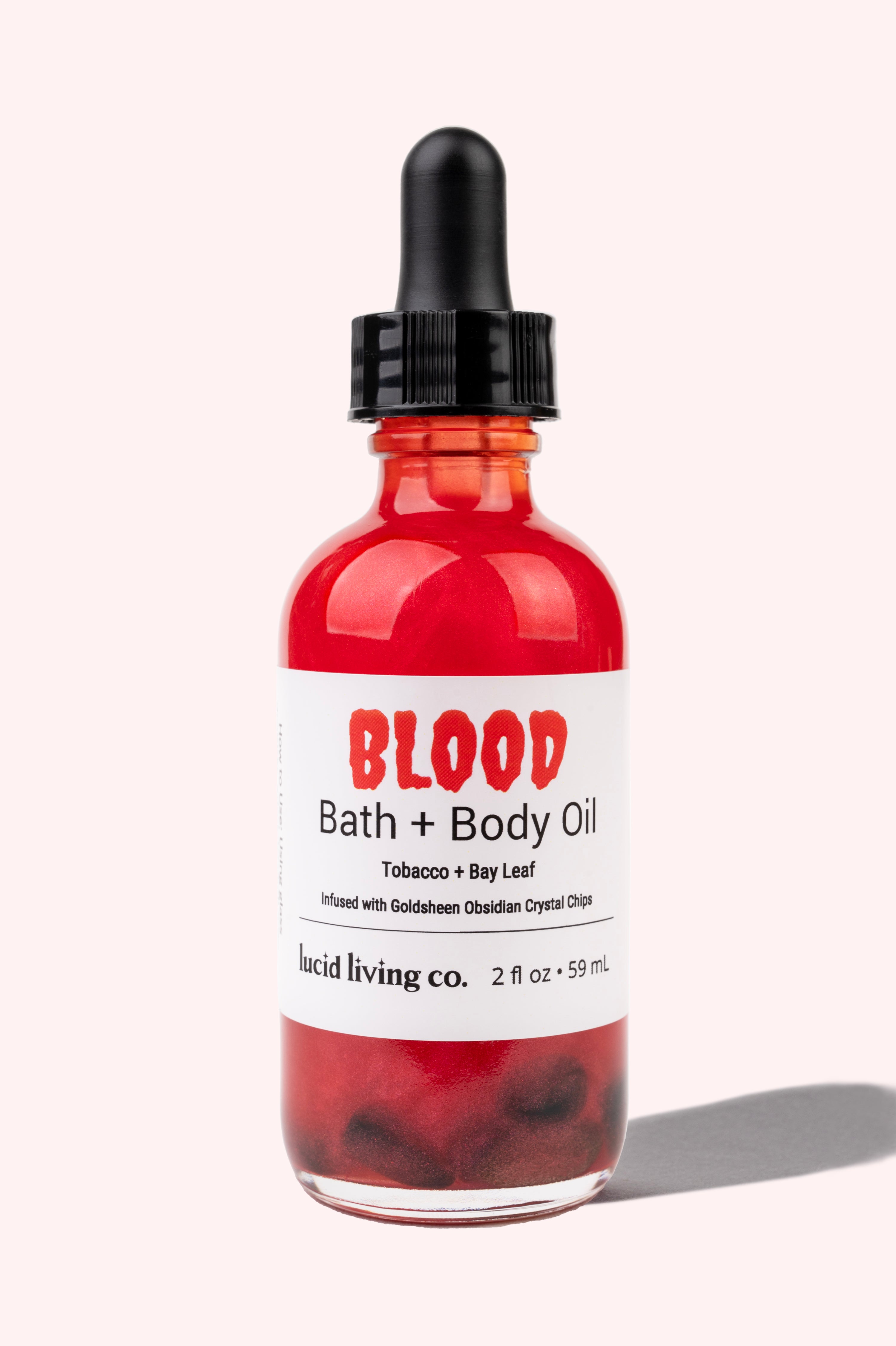 BLOOD Bath & Body Oil with tobacco, bay leaf, and Goldsheen Obsidian chips in a red dropper bottle.