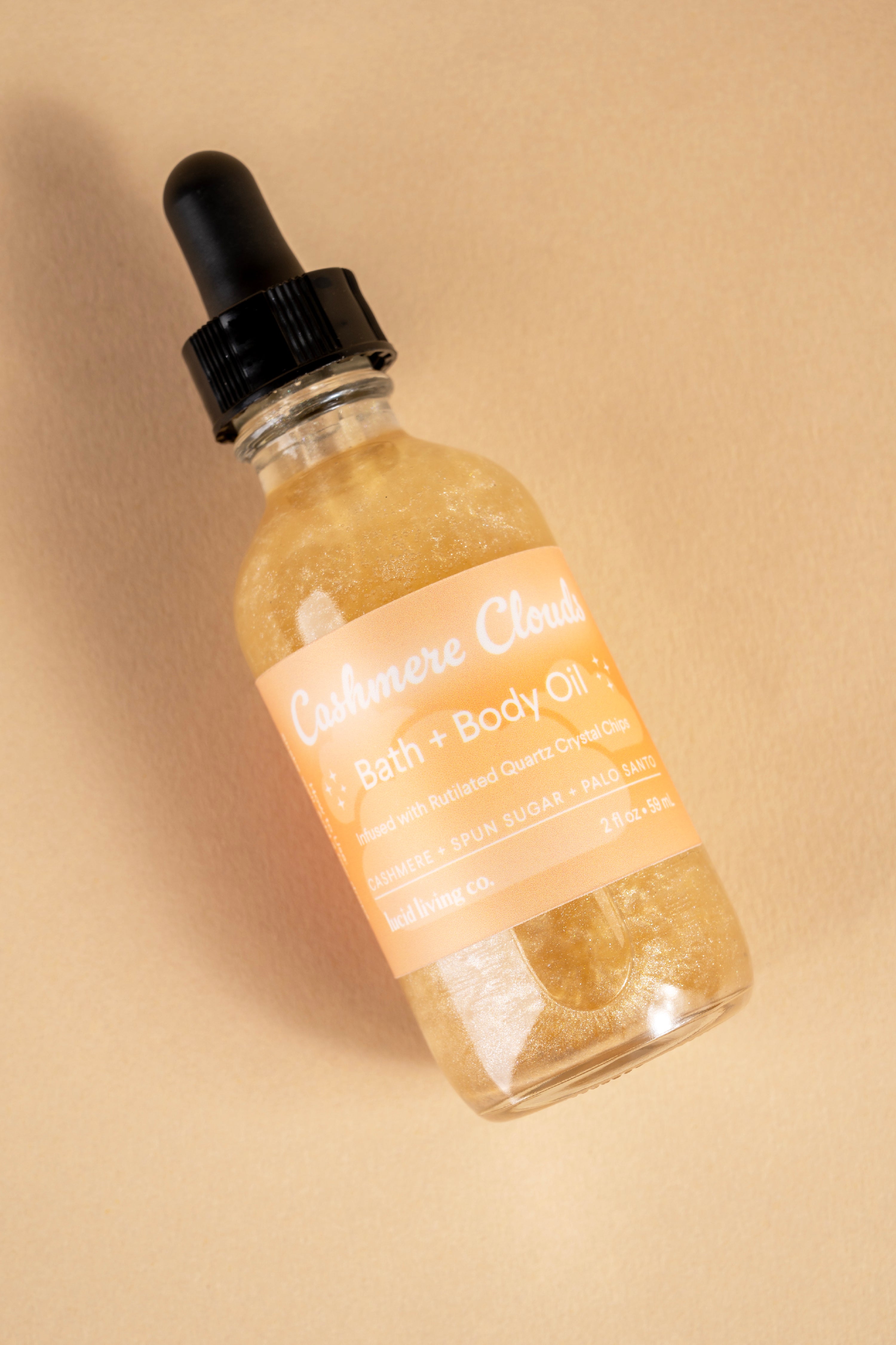 Cashmere Clouds Bath & Body Oil with rutilated quartz crystal chips and a scent of cottony linen and palo santo.