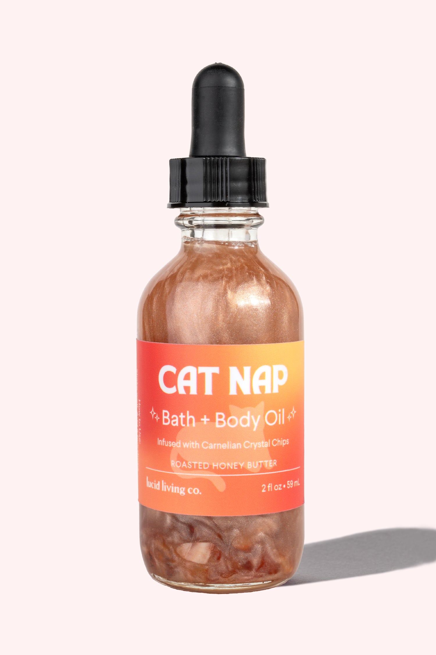 Cat Nap Bath & Body Oil in glass dropper bottle with orange label and shimmering oil inside.