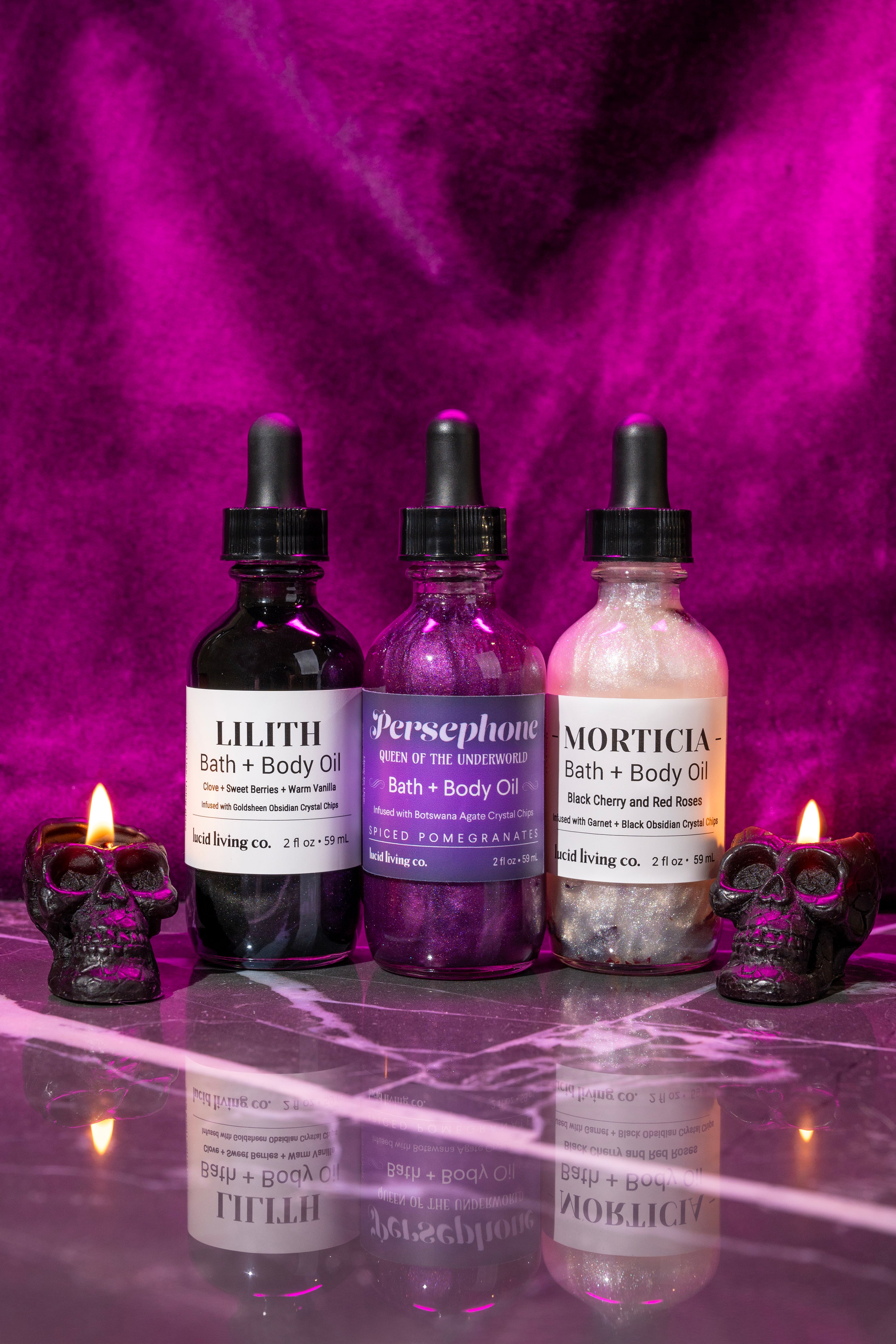 Dark Goddess Bundle featuring three bath and body oils with mystical names and dark skull candles on marble surface.