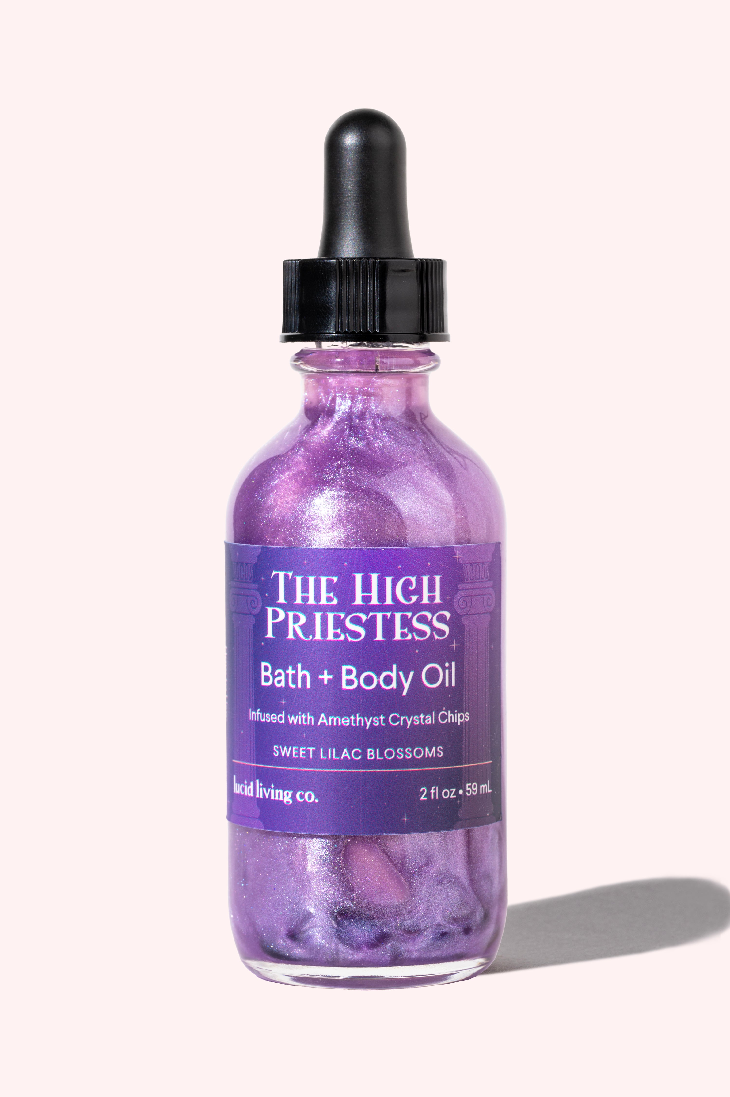 The High Priestess Bath & Body Oil with lilac scent and amethyst crystal chips for calming and healing energy.