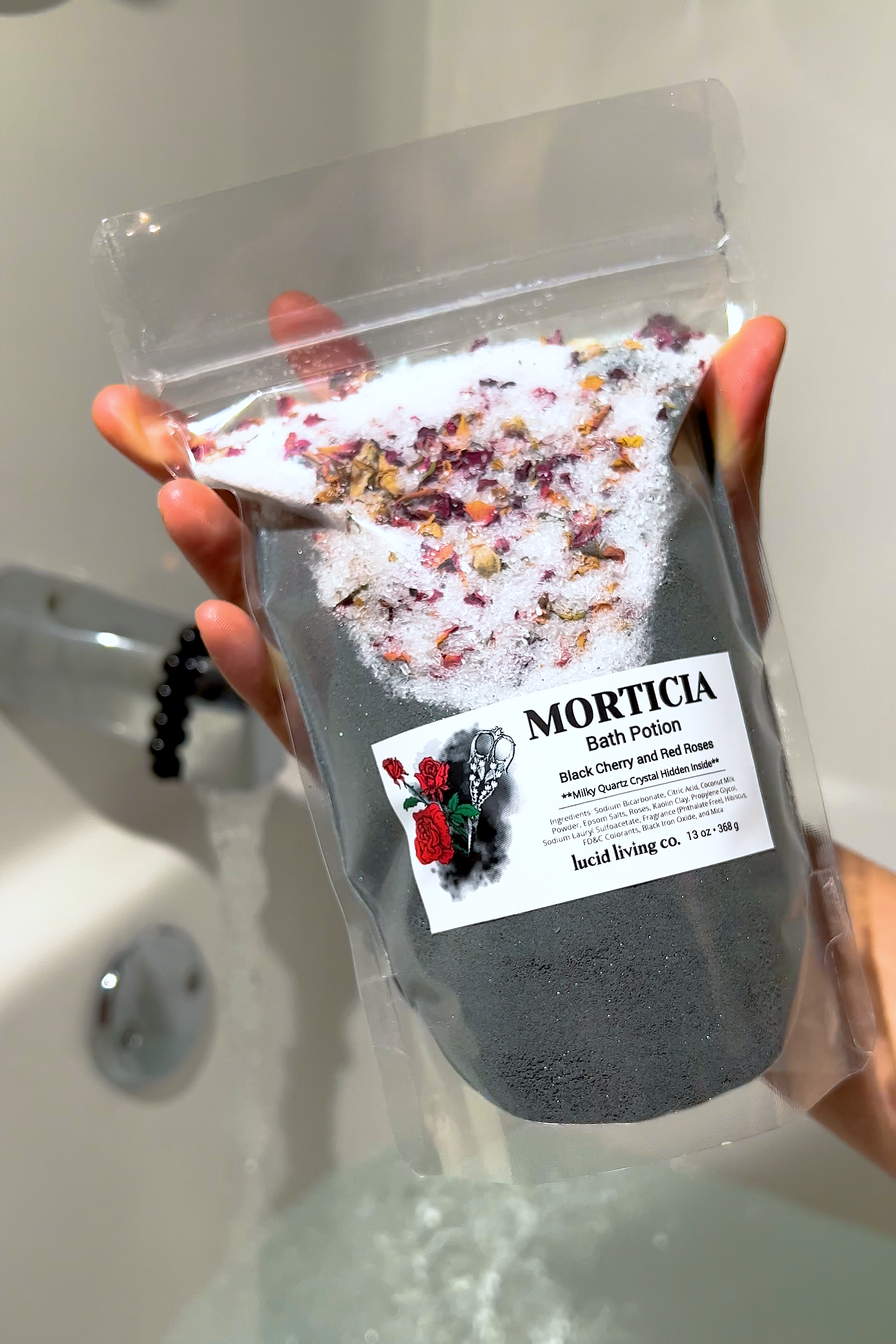 Morticia Bath Potion with black cherry, red rose petals, and soothing Epsom salts for a relaxing bath experience.