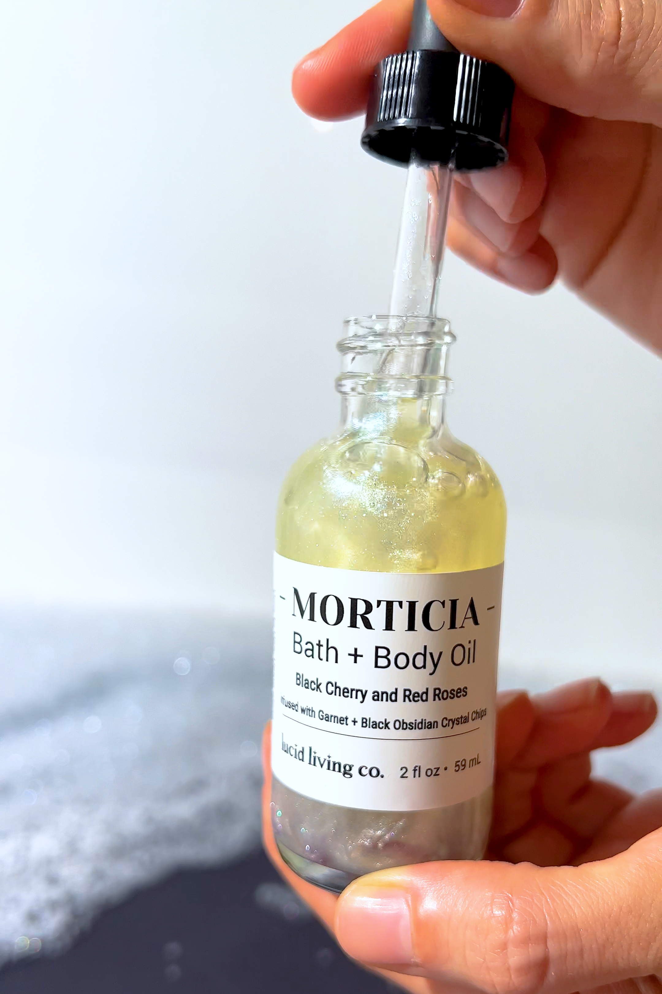 MORTICIA Bath & Body Oil with black cherry, red roses, garnet, and black obsidian crystal chips for energy shielding.