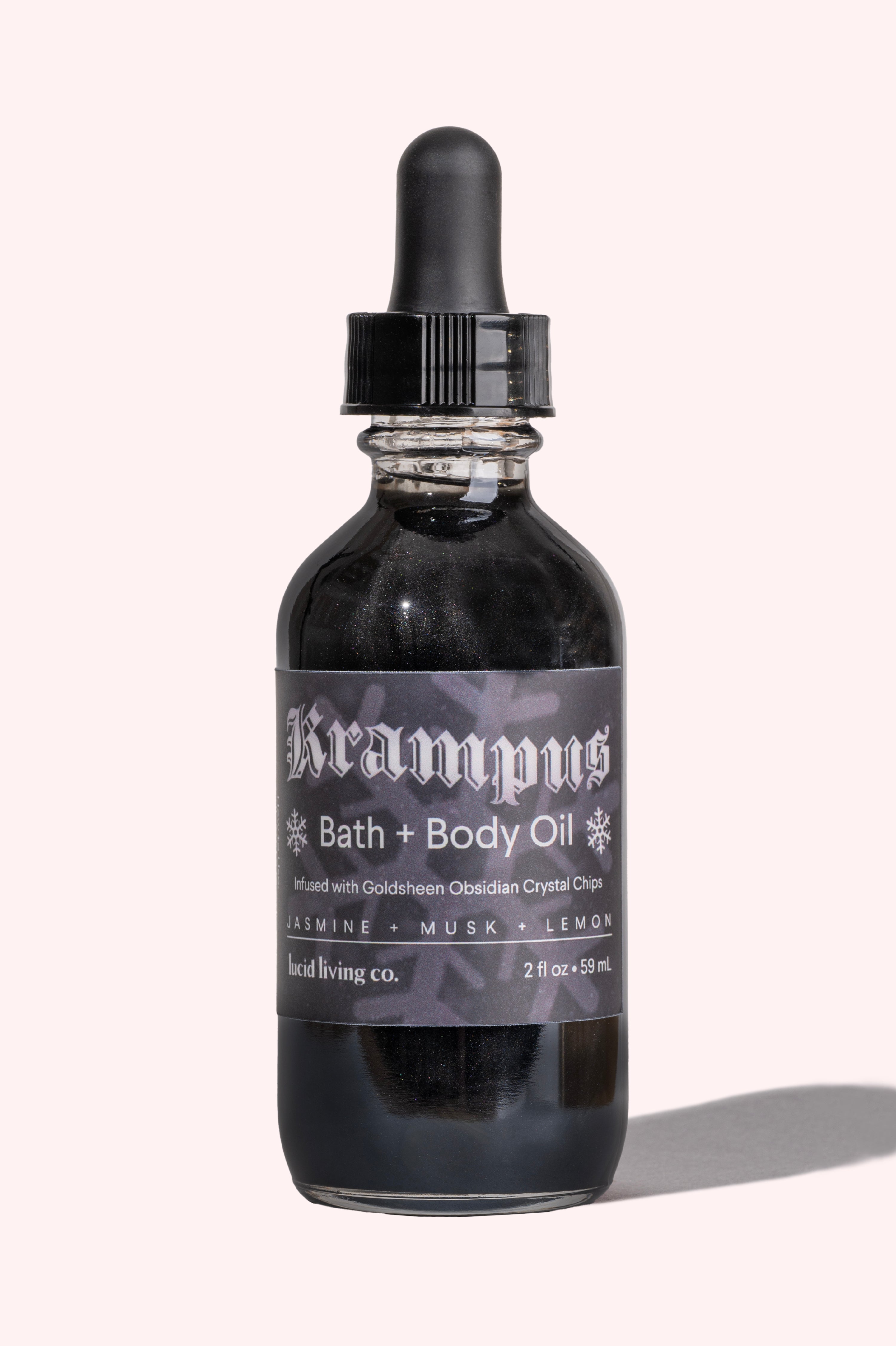Krampus Bath & Body Oil bottle with black liquid, infused with Goldsheen Obsidian crystal chips and scented jasmine musk lemon.