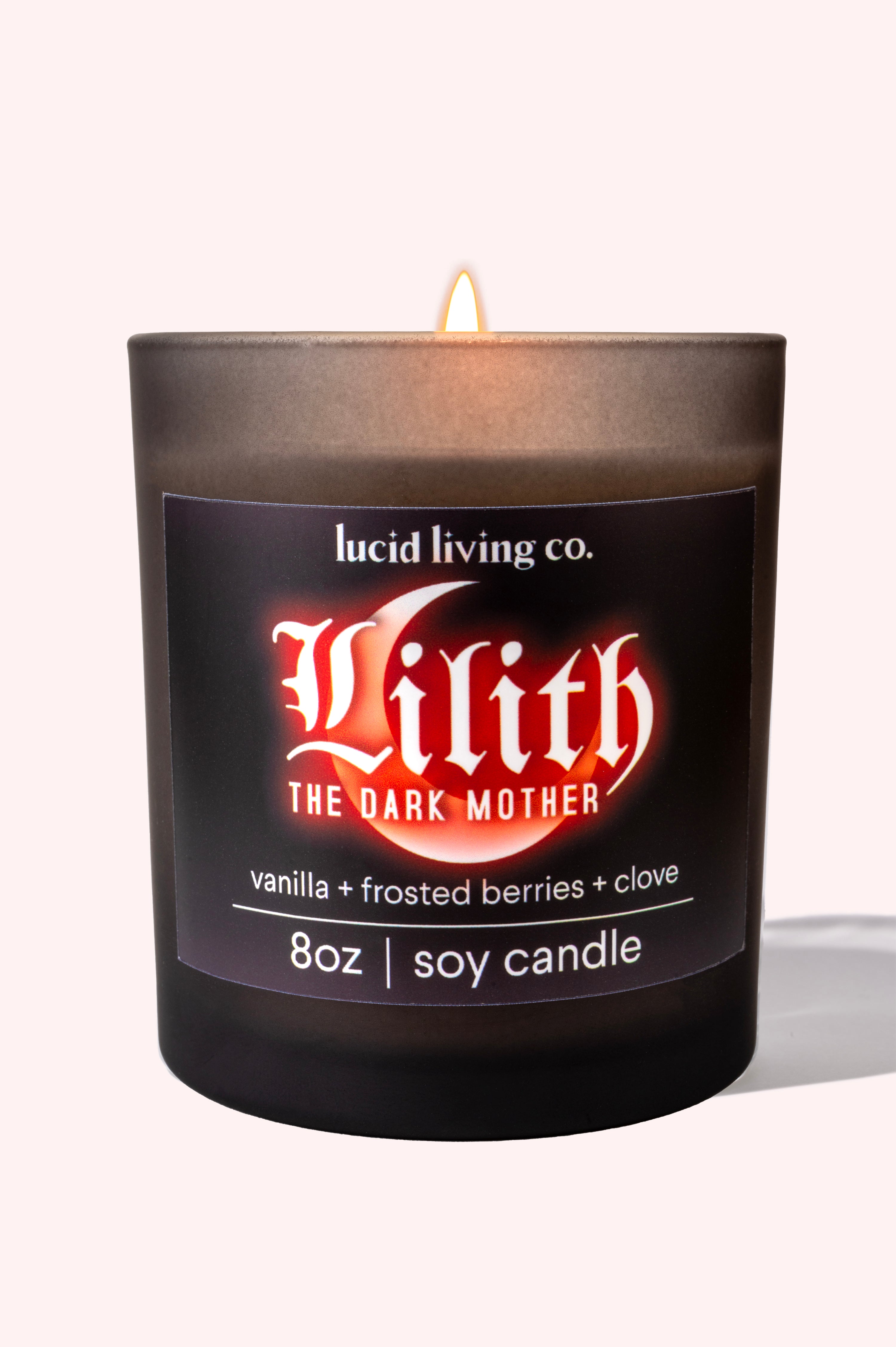 Lilith Soy Candle lit in black frosted glass with vanilla, frosted berries, and clove scent by Lucid Living Co.