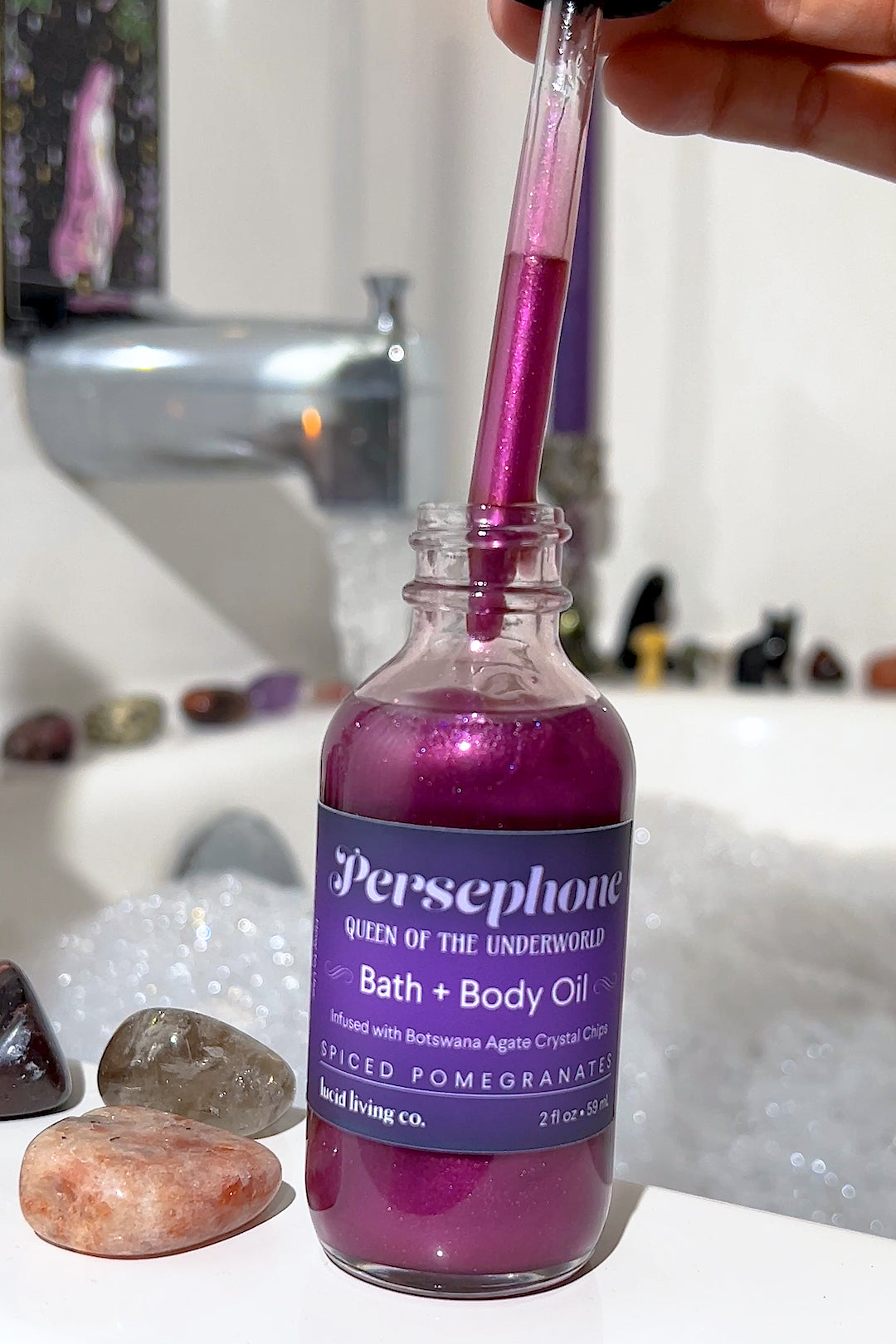 Persephone Bath & Body Oil with spiced pomegranate and Botswana Agate crystal chips for emotional balance.