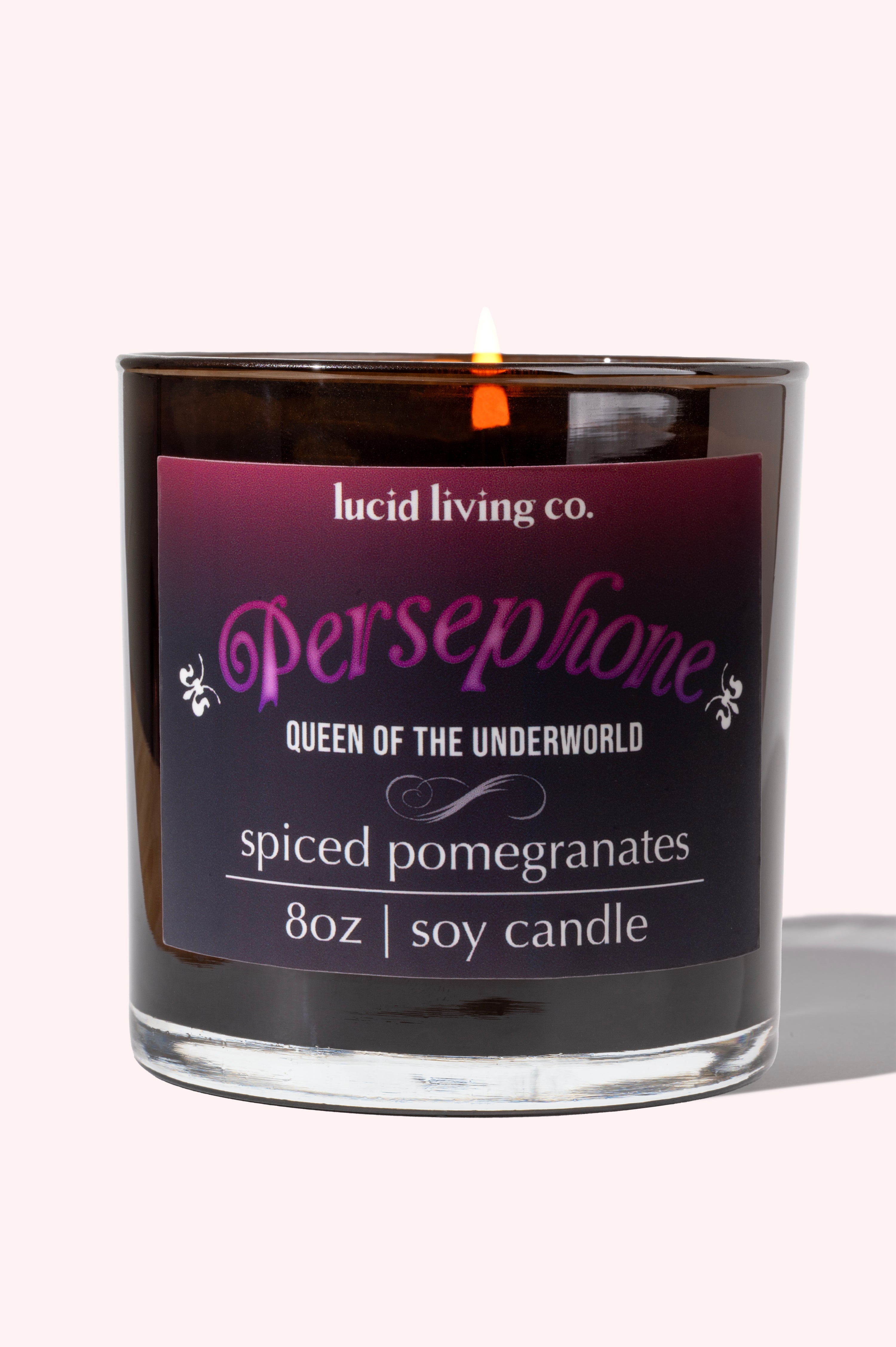 Persephone Soy Candle in shiny black jar with spiced pomegranate scent, inspired by the goddess’s divine fruit.