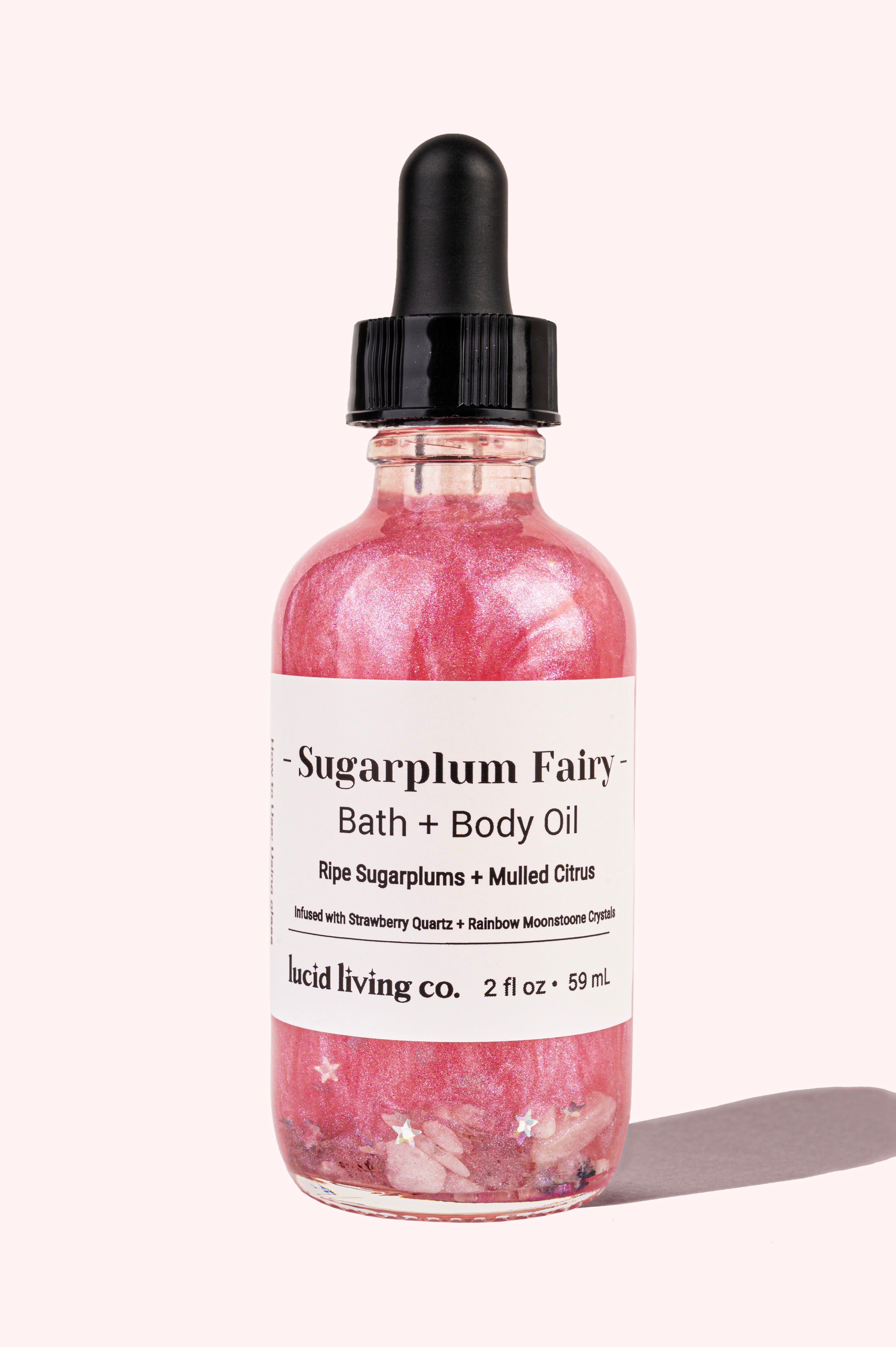 Sugarplum Fairy Bath & Body Oil with shimmering pink hue and infused crystals for a festive holiday glow.