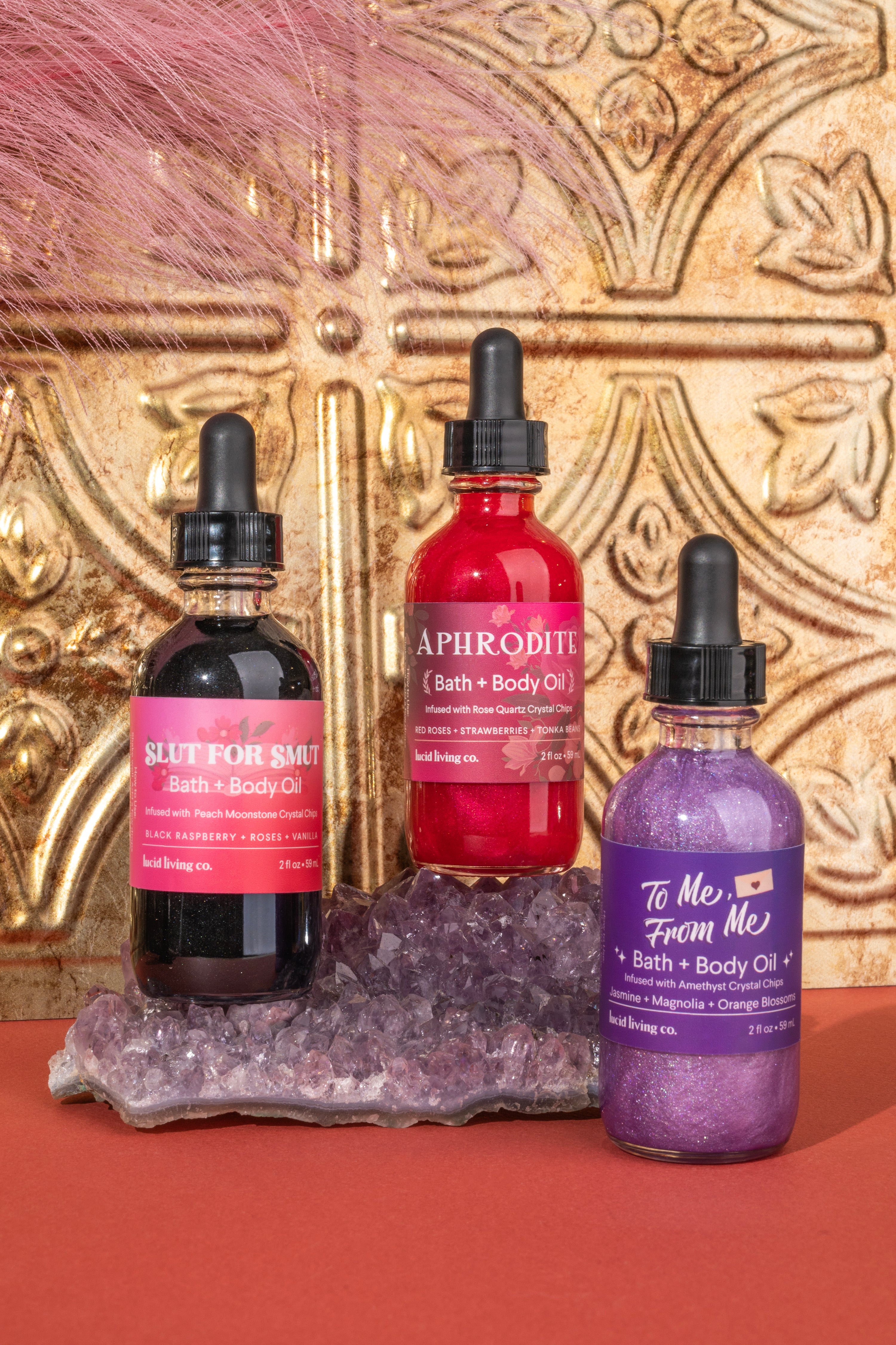 Velvet Love Bundle featuring three bath and body oils on amethyst crystal cluster with ornate gold backdrop