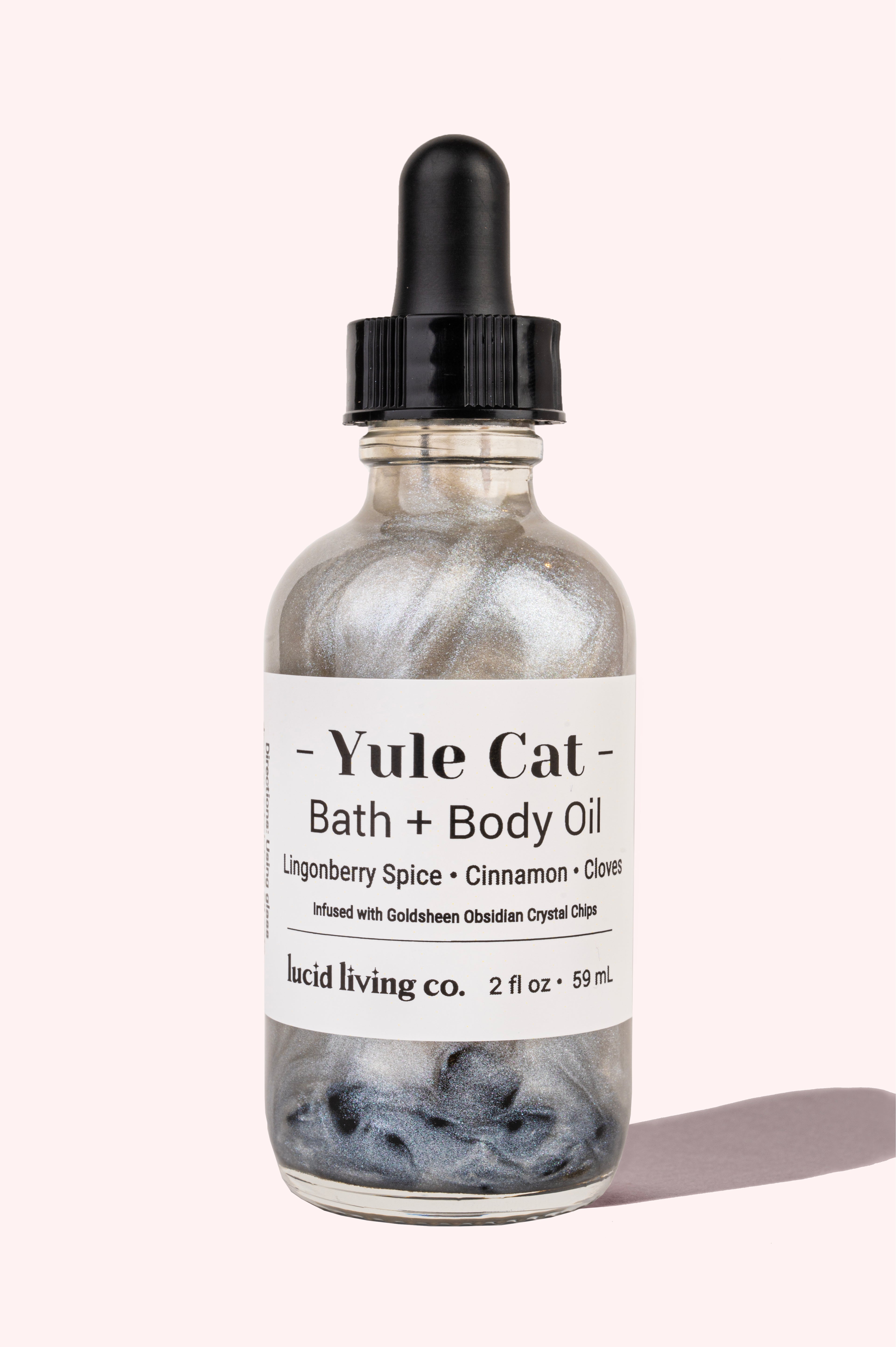 Yule Cat Bath and Body Oil with lingonberry spice, cinnamon, cloves, and Goldsheen Obsidian crystal chips in 2 oz bottle.