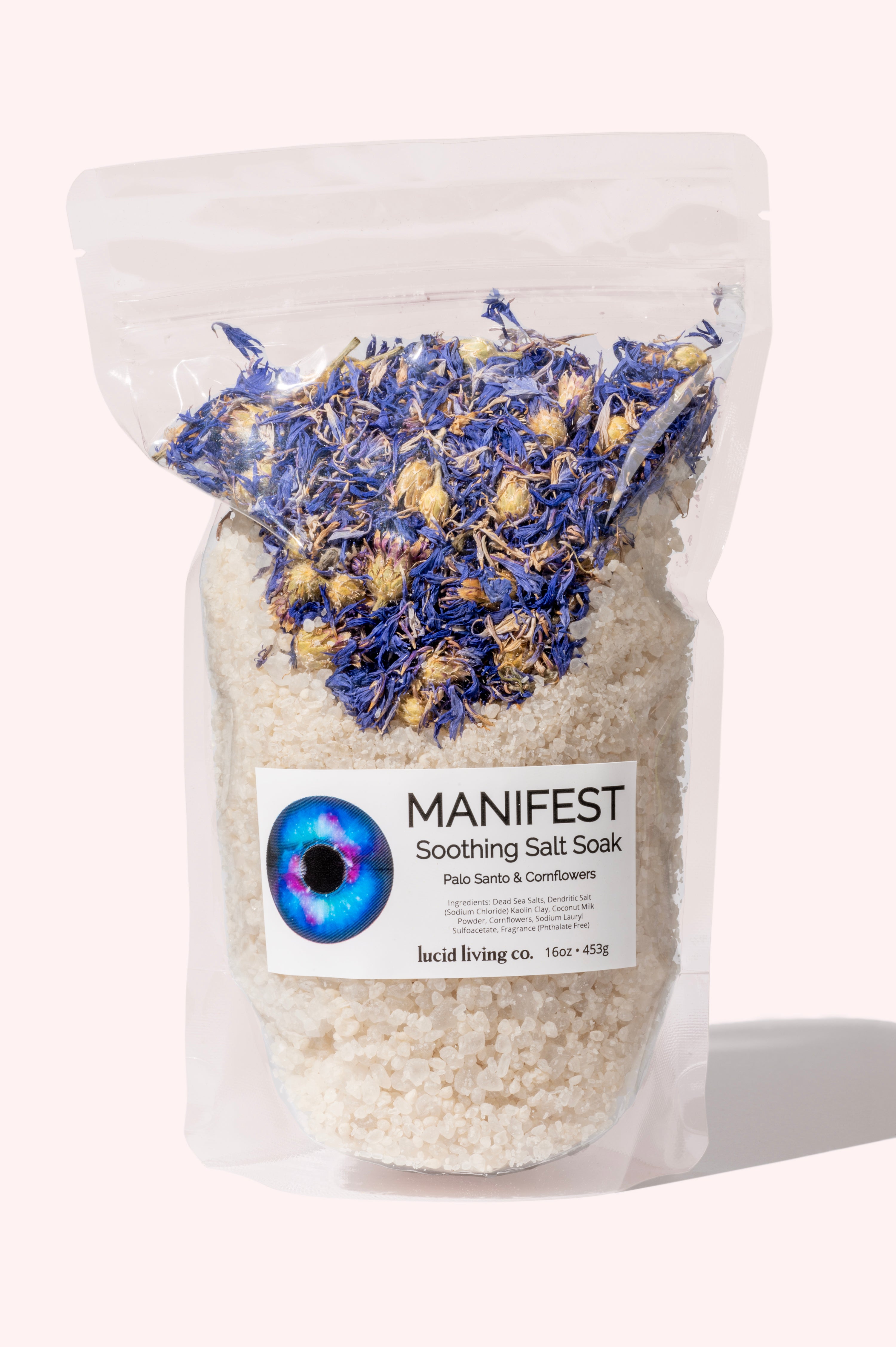 Clear pouch of MANIFEST Soothing Salt Soak with dried cornflowers and Palo Santo scent visible inside.