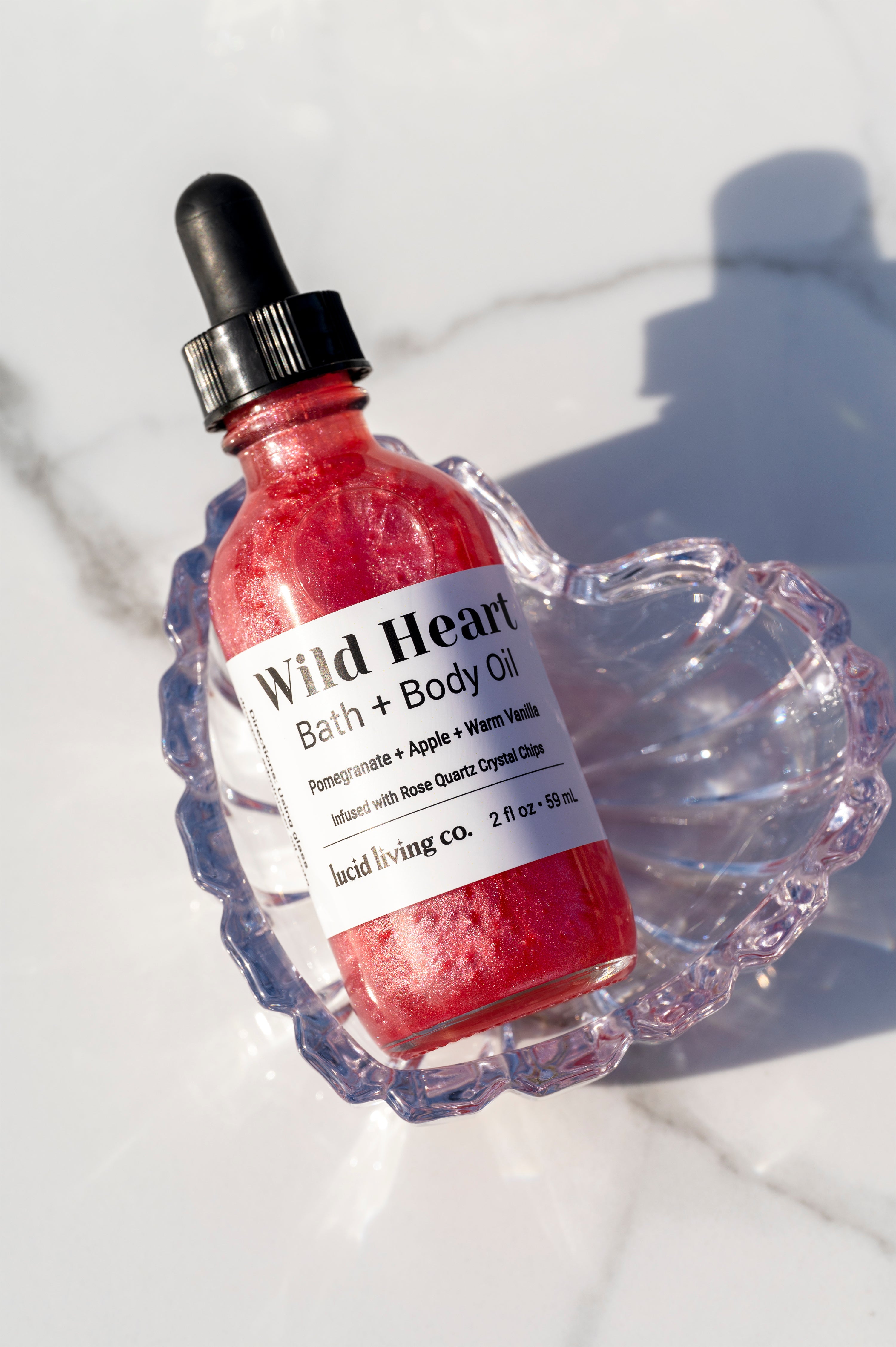 Wild Heart Bath & Body Oil shimmering pink oil with pomegranate, apple, vanilla, and Rose Quartz crystal chips.