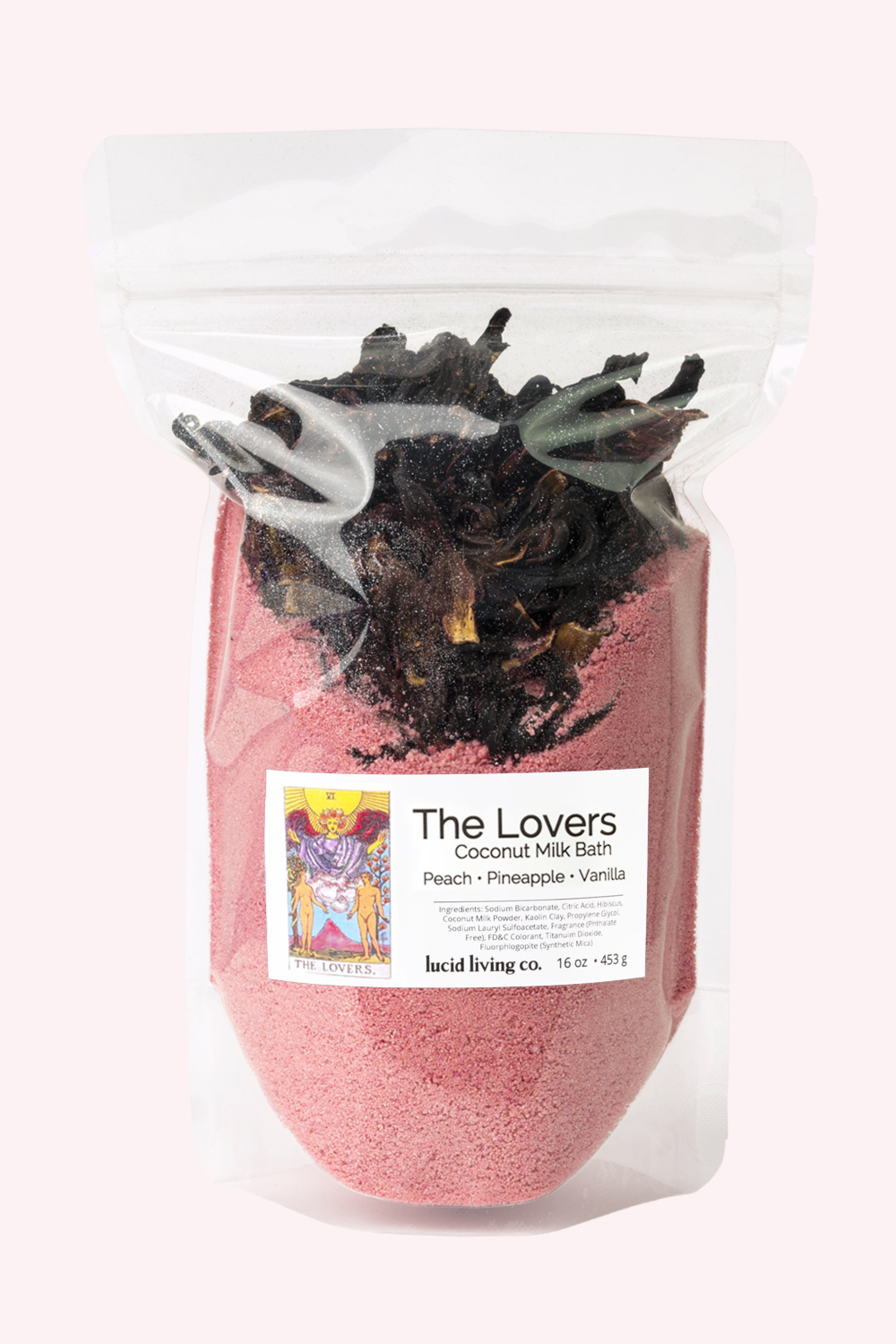 The Lovers Coconut Milk Bath in resealable pouch with peach, pineapple, and vanilla scent, red bath powder topped with dried hibiscus petals for a soothing soak.